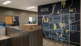 A modern office space featuring a large wall map of Downers Grove, showcasing streets and landmarks, in a professional setting.