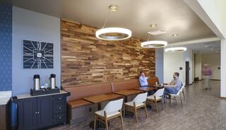 A modern café interior features wooden accents, stylish lighting, comfortable seating, and a relaxed atmosphere for conversation and dining.