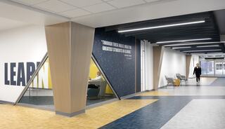 A modern hallway features bold wall text, sleek architecture, and seating areas, promoting a vibrant learning environment.