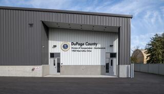A modern building with a gray and white exterior, featuring a sign for DuPage County's Division of Transportation and Maintenance.
