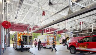 A modern fire station features emergency vehicles, firefighters in action, and bright, spacious interiors geared for quick responses.