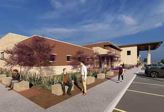 A modern building features landscaped seating areas and patrons relaxing outdoors, with a backdrop of clear skies and vibrant vegetation.