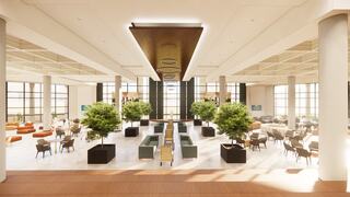 A spacious, modern lobby featuring stylish seating arrangements, greenery, and large windows allowing natural light to fill the area.