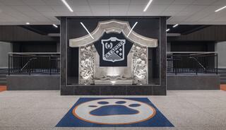 A modern indoor space features a decorative emblem with intricate details, surrounded by stylish flooring and a prominent paw print design.