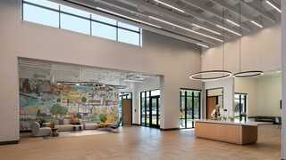 A spacious lobby features a welcoming reception area and a vibrant mural, complemented by modern furnishings and abundant natural light.