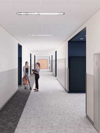 A modern, bright hallway features two women chatting near lockers, with stylish finishes and clear signs leading to rooms.