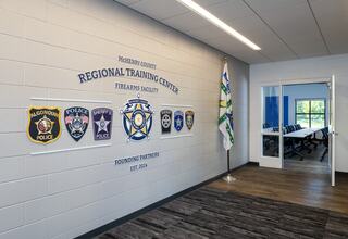 A modern training facility displays badges from various police departments, highlighting collaboration and community safety.