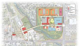 A detailed site plan showing various buildings, roads, and landscaping elements laid out in distinct color-coded zones.