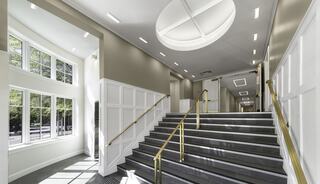 An accessible church entry with elevator and stairs, large windows, and modern ceiling design, creating an inviting atmosphere.