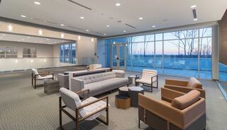 A modern church building with an interior loft featuring large windows with natural light, and a welcoming atmosphere, perfect for relaxation or conversation.