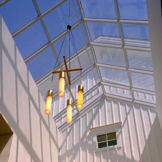 A church interior with a glass ceiling, featuring a stylish pendant light and white walls, evokes a bright and airy atmosphere.