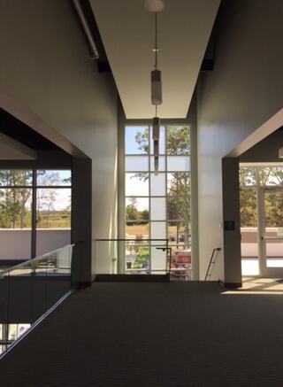 A church stairwell features a cross in large windows that allow natural light to enter the space.