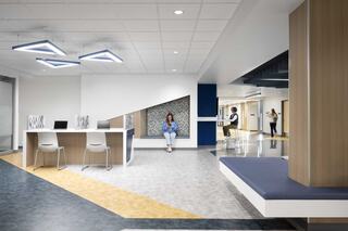 A modern open space featuring sleek furniture, vibrant flooring, and unique lighting, encouraging collaboration and relaxation.