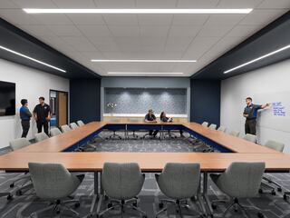 A modern conference room features a large table, comfortable chairs, and group discussions, enhancing collaboration and creativity.