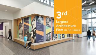 Interior hallway at Caseyville Elementary School featuring bright, natural light and a community mural with a corner bench. Two young students sit on the bench.