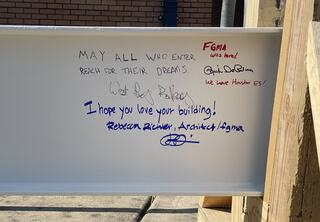 Signatures and hopeful wishes, next to children's handprints, fill the final beam that will be part of the topping out ceremony for Austin ISD's new Houston Elementary School building.
