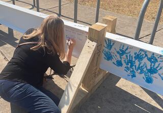 FGMA Principal Rebecca Richter signs the final beam that will be part of the topping out ceremony for Austin ISD's new Houston Elementary School building.