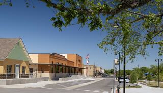 Looking down a road at the new Elgin, Texas police department building that sits in the historic section of downtown Elgin, across the street from an expanded community park.