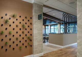 Interior design details at Jersey Village Golf Club: living green wall, art deco inspired room separator, modern patterned wallpaper, floor to ceiling windows in the players dining and lounge area.