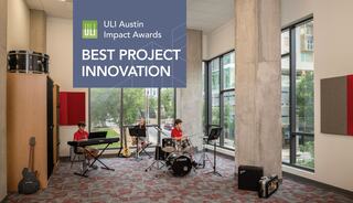 young students play a drum set, saxophone and keyboard in a tall music room with floor-to-ceiling windows and grey and red accent colors, part of St. Austin Catholic School's renovation.
