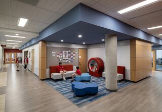 A modern, inviting educational space featuring colorful seating areas, children engaged in activities, and vibrant wall decorations.