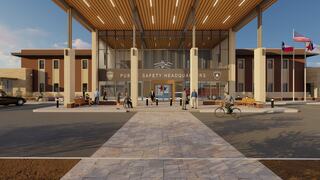 A modern public safety headquarters features a welcoming entrance, landscaped pathways, and people engaged in various activities outside.