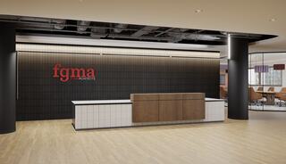 A modern reception area features a sleek wooden desk against a dark wall with the "fgma architects" logo, complemented by light wood flooring.