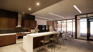 A modern kitchen features wooden cabinets, sleek appliances, and a spacious layout with seating, illuminated by bright lighting.