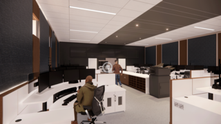 A modern office space features multiple workstations with computers, sleek furniture, and a professional atmosphere. Two individuals are present.