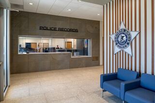 Welcoming public facing lobby at the police department in the Downers Grove Civic Center, featuring a star badge graphic on one wall and service windows on another