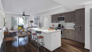 A modern open concept apartment featuring sleek cabinetry, an island with seating, and a cozy living area with natural light and stylish decor.