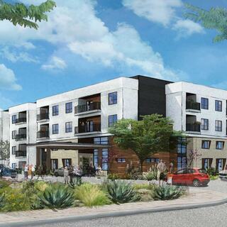 A modern, multi-story residential building features balconies, landscaped areas, and people socializing outside under a bright sky.