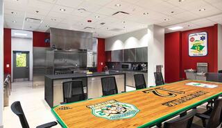 Modern fire station kitchen with stainless steel appliances, an inviting dining table, and vibrant red walls. Ideal for communal gatherings.