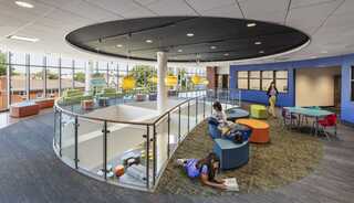 A modern learning space in the new Sherlock Elementary School featuring colorful seating, natural light, and areas for reading and collaboration, fostering a dynamic environment.