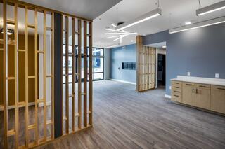 A modern, open leasing office featuring wooden partitions, neutral walls, and sleek lighting, creating a bright and inviting atmosphere.