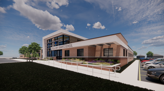 A modern school building features an expansive facade with large windows, surrounded by greenery and a parking lot under a bright sky.