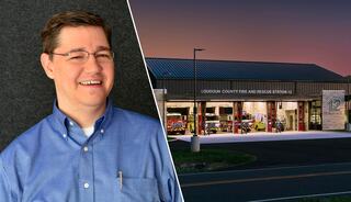 A smiling man in a blue shirt is juxtaposed with a fire station at dusk, showcasing rescue vehicles and the building's modern design.