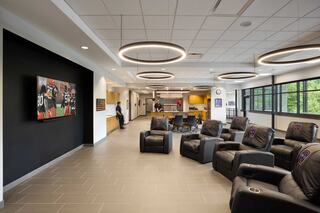 A modern lounge features comfortable recliners, a large TV, and contemporary decor, creating a relaxed and inviting atmosphere.