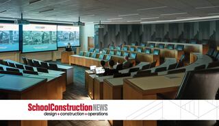 A modern lecture hall with tiered seating, large screens, and a sleek design, designed for presentations and collaborative learning.