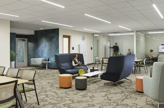 A modern open space features comfortable seating, collaborative areas, and a relaxed atmosphere, encouraging interaction and productivity.