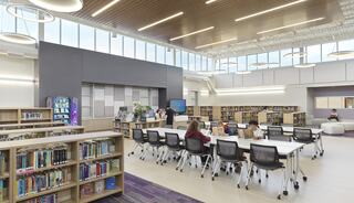 A modern library featuring large windows, colorful bookshelves, and groups of people engaged in reading and studying at collaborative tables.