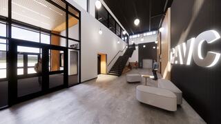 A modern, bright entryway features a staircase, seating area, and bold signage, creating an inviting atmosphere for visitors.