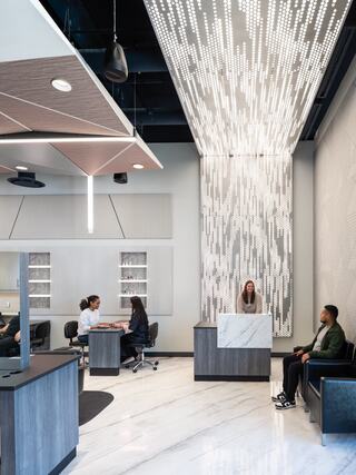 A modern salon studio reception area features sleek furniture, a striking light installation, and a welcoming atmosphere for visitors.