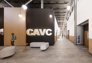 A spacious, modern corridor featuring a prominent "CAVC" sign, stylish seating, and well-lit areas with a minimalist design.