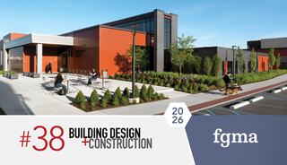 A modern building features sleek architecture with orange and gray tones, surrounded by greenery and outdoor seating areas.