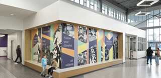 A vibrant entrance with colorful murals promoting dreams and achievements, featuring images of people and inspirational messages.