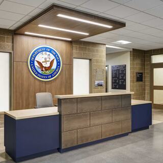 A modern building features a unique design with a green roof, yellow brick, and decorative elements, set against a clear blue sky.
