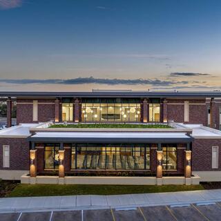 A rooftop features solar panels, contributing to sustainable energy. Surrounding greenery and vehicles suggest an active community space.