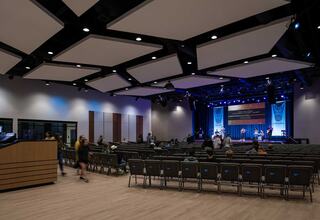 A child browses a modern library with large windows, showcasing bookshelves and a bright, airy atmosphere.