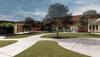 A modern educational building surrounded by lush greenery, featuring colorful entrances and walkways that create an inviting atmosphere.